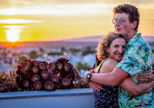 Mother hugging her son at sunset