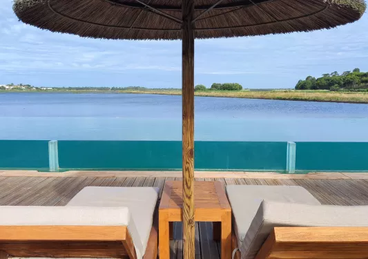 Recliners and umbrella, seaside relaxation area.