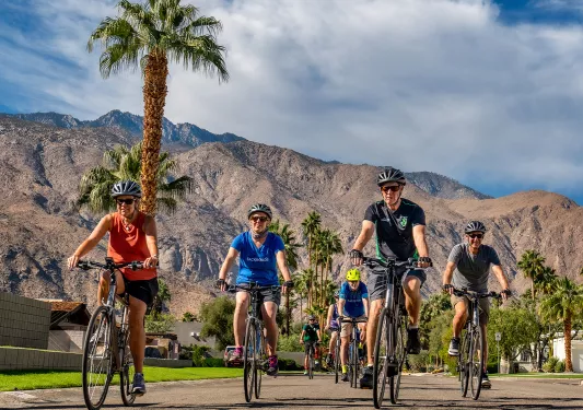 Group of guests cycling through Palm Springs neighborhood.