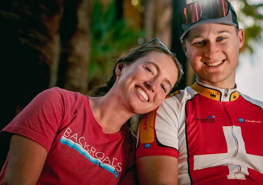 Two guests smiling for camera, one is leaning on the other's shoulder.