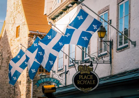 Storefront shot of "PLACE ROYALE", Quebec flags proudly displayed.