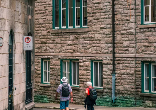 Two guests walking down brick-housed alleyway.
