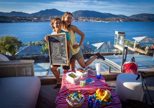 Two guests/leaders at a hotel, ocean and hills in background.