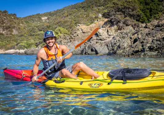 Man in a yellow kayak laughing 