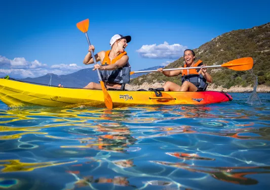 Two guests in kayak, smiling and laughing.