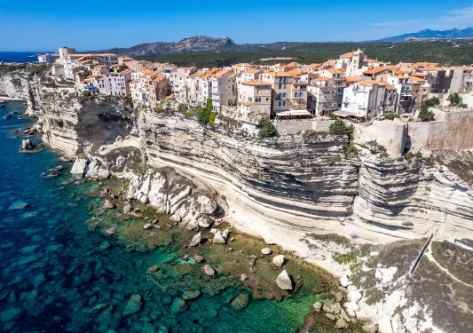 Wide shot of Corsican coastline. Houses dotting the hillside.