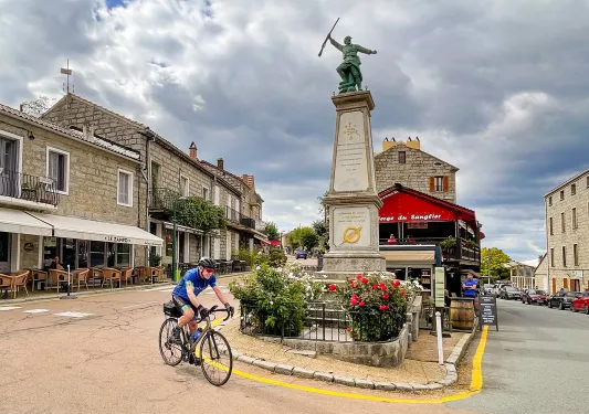 Guest cycling through town square in Zonza.