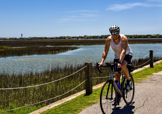 Guest cycling past grassy bog.