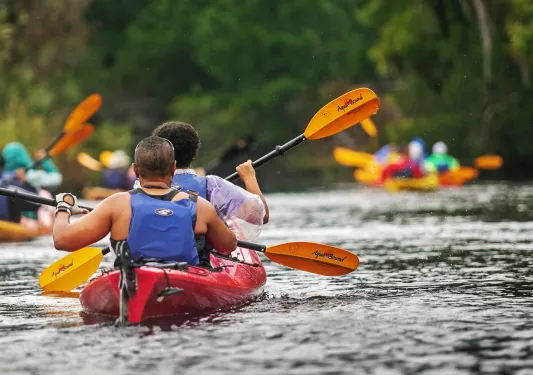 Group of guests kayaking in the rain.