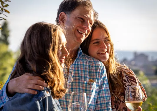 Father laughing a posing with daughters