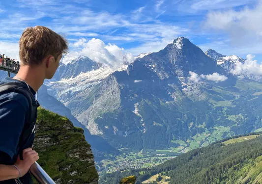 Guest on bridge, overlooking mountain vista.
