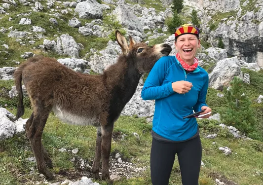 Guest on mountain trail, donkey beside her.