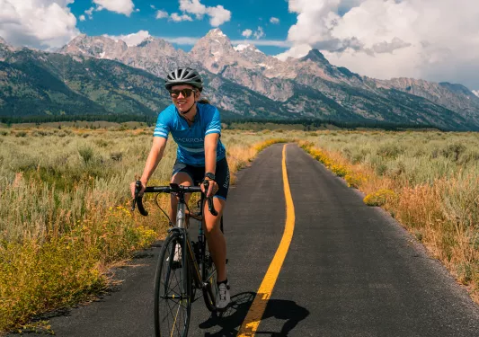 Backroads guest riding on a narrow road surrounded by green fields