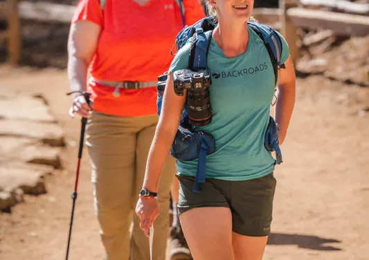 Leader and two guests hiking on trail.