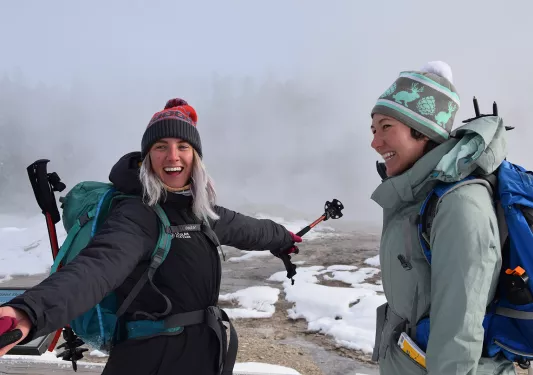 Backroads guests smiling near snowy hot springs