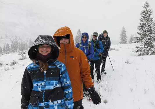 Backroads guests smiling while cross country skiing during blizzard
