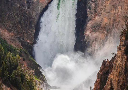 Large waterfall casting out spray in valley