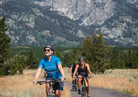 Backroads guests smiling while riding through mountain road
