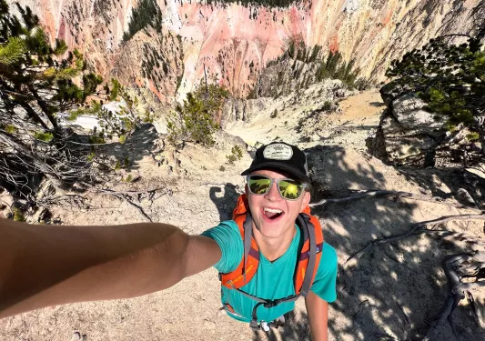 Backroads guest taking a selfie at the top of a mountain