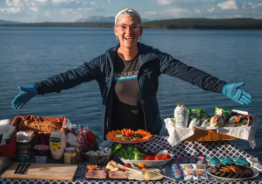 Backroads leader smiling while providing lunch for guests 