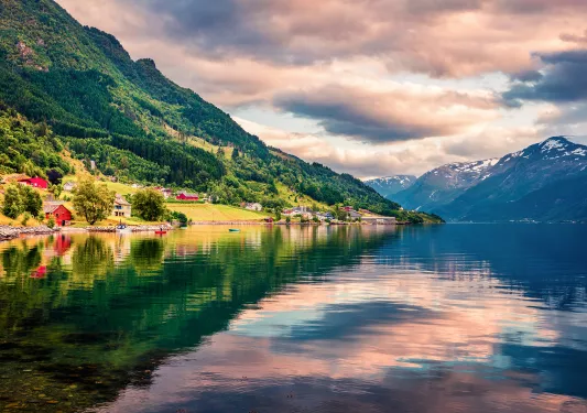 Pink sky reflected in crustal clear waters in a Norwegian fjord
