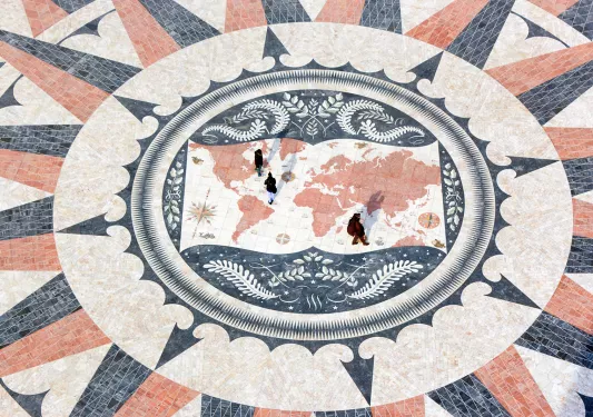 Mosaic tiles in a design that looks like a compass overlaid with a map