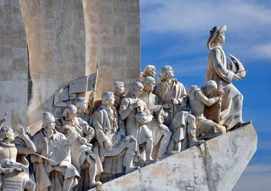 Close-up of intricate marble sculptures on building overhang.