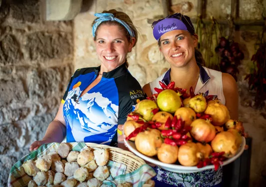 Leaders/guides holding platters of food. Scones, pomegranates, chili's, etc.