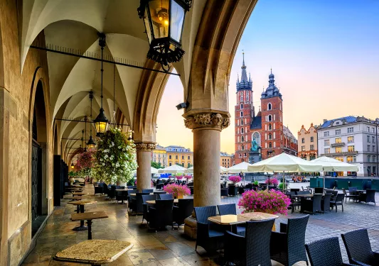 Building courtyard with cafe seating  overlooking a square.