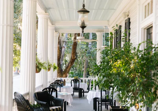 Shot of southern style home deck, chairs all around.
