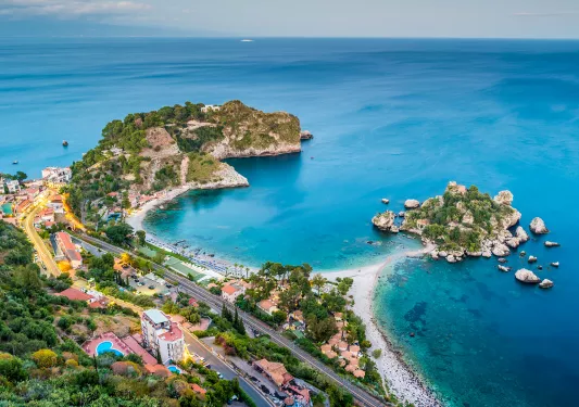 Bird's eye shot of colorful Italian coastline. Blue water and multi-colored houses.
