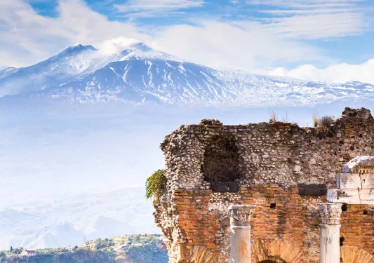 Shot of mountains in distance. Sandstone ruins in foreground.