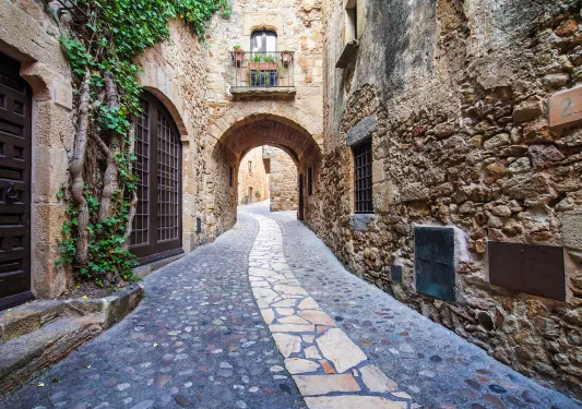 POV shot of stone alleyway, doors, windows, arches.