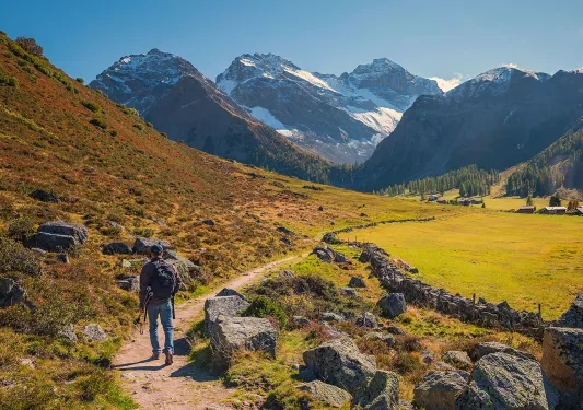 Hiker walking along trail in Swiss Alps.