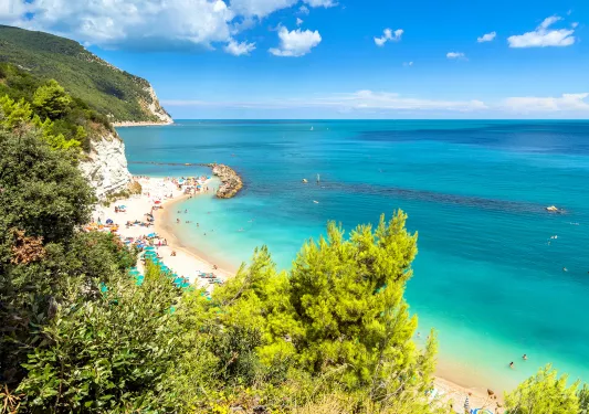 Wide shot of vibrant blue coast, ocean in distance.