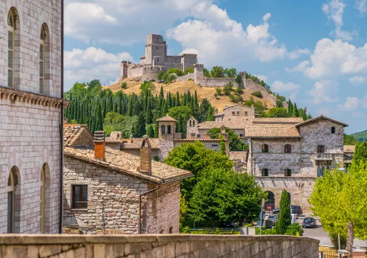 Wide shot of brick villages, large brick building on hilltop.