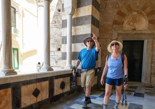 Two guests walking through arched cathedral.