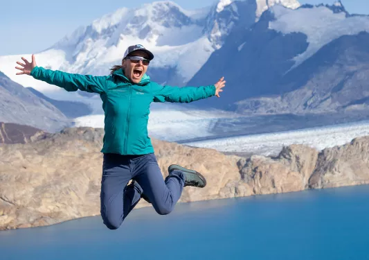 Woman posing for camera, jumping into air.