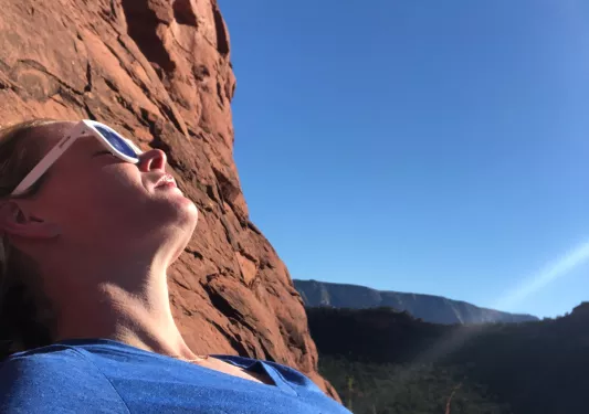 Woman resting on a hike, sunbathing.