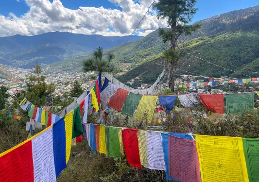 Brightly colored flags strung up above a valley in Bhutan