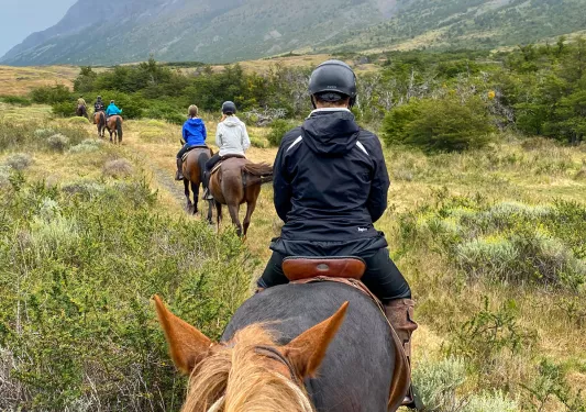 Point of view shot of guests on horseback, heading towards ring of mountains.