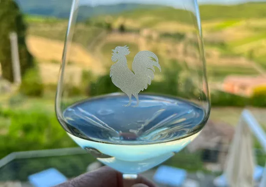 Close-up of wine glass, rooster engraved into it.