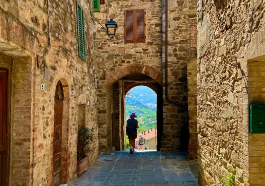 Guest walking under brick building arch.