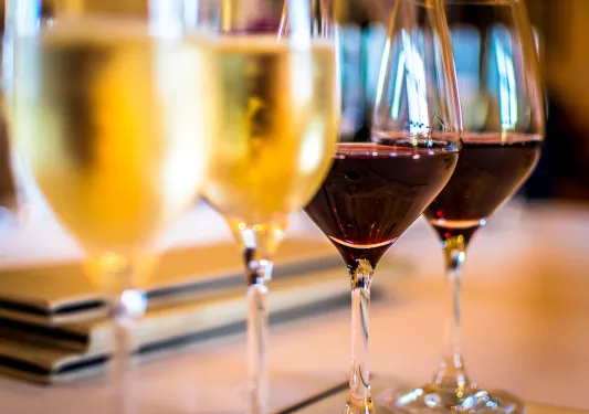 Close-up of four wine glasses, two red, two white.