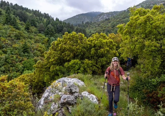Backroads hiker on trail in dense wilderness in Greece.