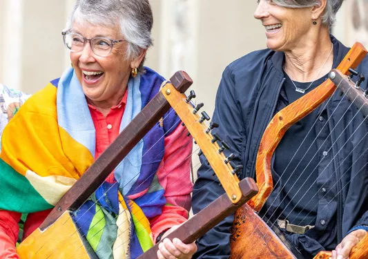 Two women playing Greek instruments.