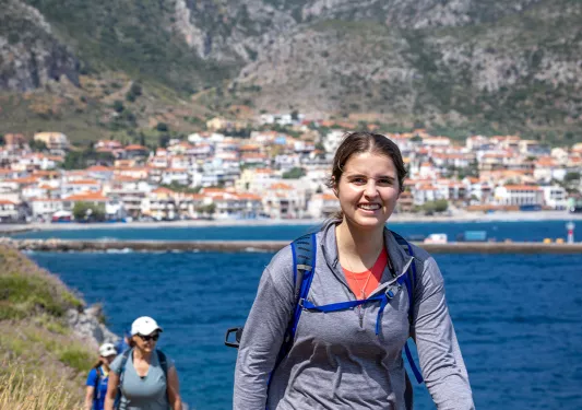 Two hikers on a trail on a beach in Greece.