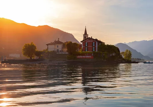 Wide shot of the Albergo Ristorante and it's surrounding lake, sunset.