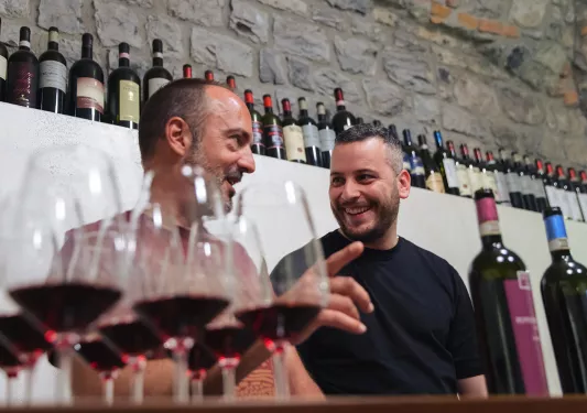 Two guests/locals at wine tasting, numerous glasses of red wine.