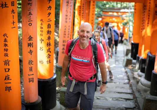 Walking up a hill among orange arches in Japan